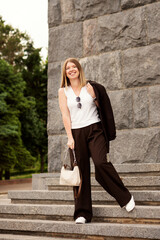 Young woman smiling confidently on city stone stairs outdoors