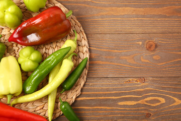 Different fresh peppers on wooden background