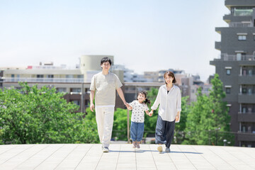 手を繋いで屋外を散歩する親子