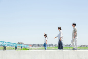 土手を行進する家族