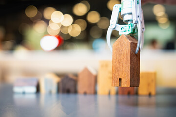 AI in real estate: A robotic arm lifts a tiny wooden house, showcasing technology's power to match homes with budgets and desired types.