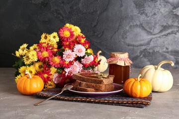 Plate of toasts with sweet pumpkin jam and seeds on grey table