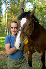 rustic man with  horse in rural village near  forest.  horse farm is surrounded by nature, hay is stacked nearby,  peaceful and traditional.  man is caring for  horse