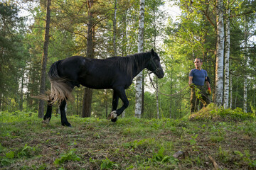rustic man with  horse in rural village near  forest.  horse farm is surrounded by nature, hay is stacked nearby,  peaceful and traditional.  man is caring for  horse