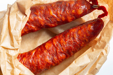 Spanish Chorizo spicy sausage in a brown paper bag background. Environmetally friendly eco biodegradable packaging concept.