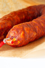 Spanish Chorizo spicy sausage in a brown paper bag background. Environmetally friendly eco biodegradable packaging concept.