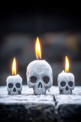 Three skull-shaped candles burning in a row
