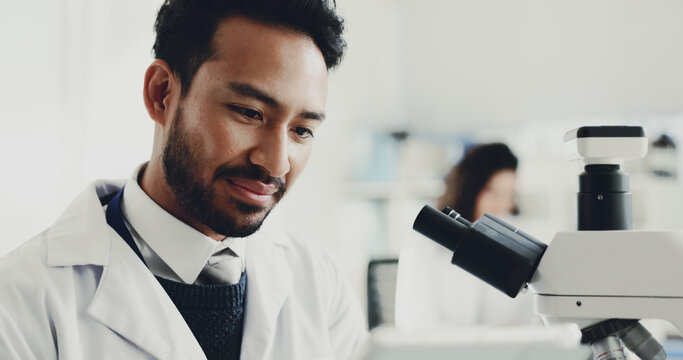 Man, scientist and laptop with microscope in lab for research, medical study and testing sample. Male person, tech and machine for experiment, dna production and review report of vaccine breakthrough