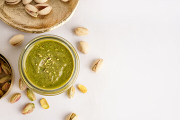 Jar of pistachio paste on white background