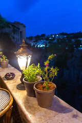 Night lantern and flower pots on a stone parapet
