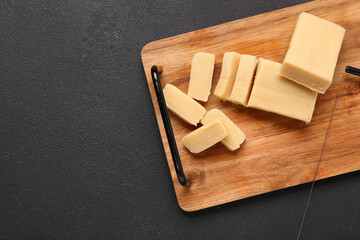 Wooden board with tasty marzipan on dark background