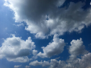 The sky is bright blue with large, thick white clouds, creating a serene and beautiful view.