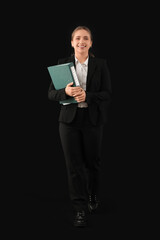 Young woman in business suit with folder on black background