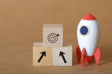 Launching Business Success: A Cartoon Rocket and Wooden Blocks Representing Strategic Growth