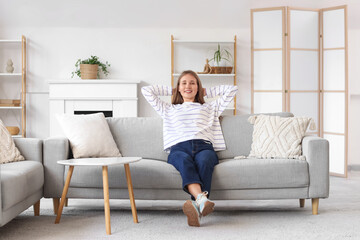 Young woman resting on soft couch at home
