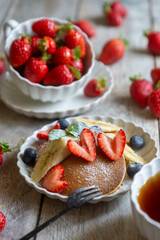 Light breakfast, pancakes with fruits and berries on the table.