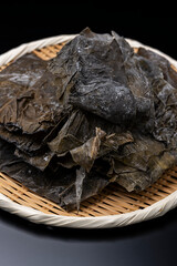 黒背景に竹ざるに盛った羅臼昆布