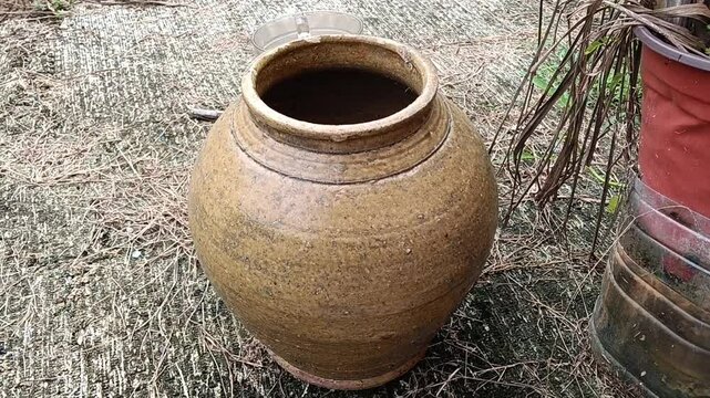 Old clay pot on the ground in the garden at kluang, johore, malaysia