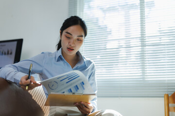 Businesswoman analyzing charts and graphs in modern office