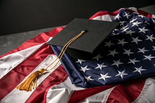 U.S. academic tradition honored by a graduation cap over the symbolic stars and stripes of the American flag