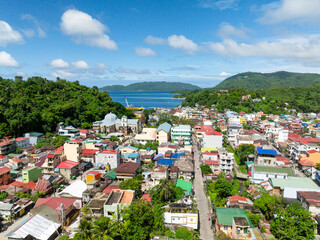 Buildings and houses in coastal town with ferry in port. Romblon Island, Romblon, Philippines.