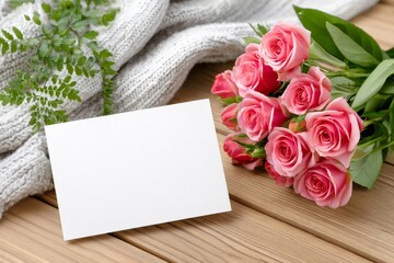 Pink roses bouquet and blank card lying on wooden table