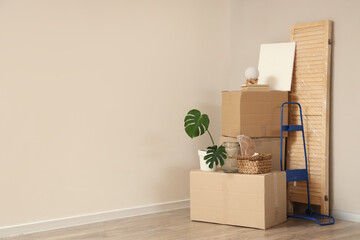 Fototapeta premium Cardboard boxes with wrapped folding screen and home decor in room on moving day