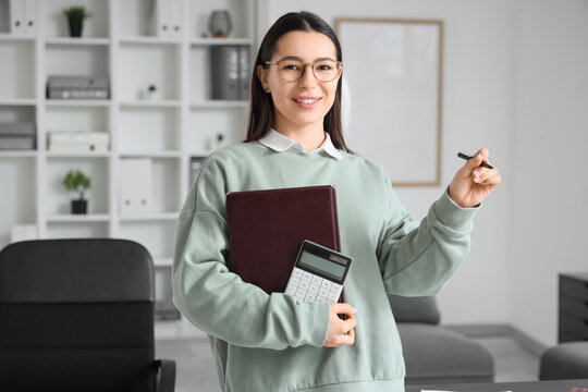 Young businesswoman with report and calculator in office - Powered by Adobe