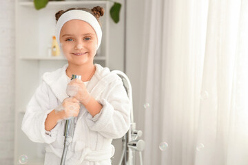 Little girl with foam and shower head singing in bathroom