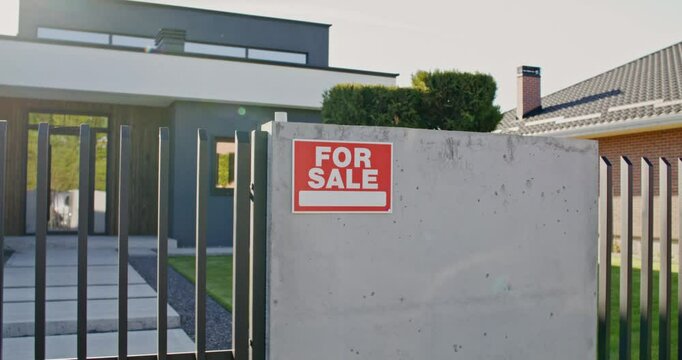 The house is for sale. Close-up of the sign on the fence with the inscription for sale