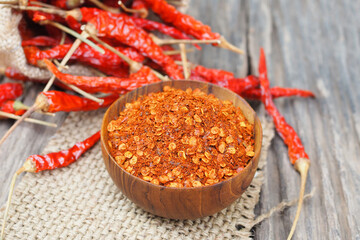 Cayenne pepper and dried chilli with sack on wooden table