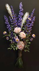 A bouquet of roses lavender and feathers is tied together against a dark background