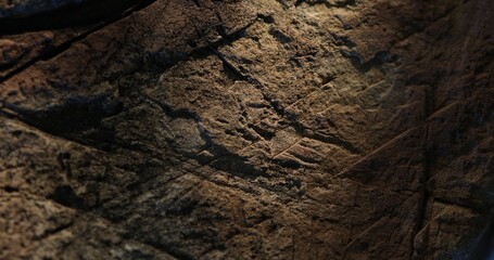 Close-up of rugged rock surface with deep split and warm blue lighting