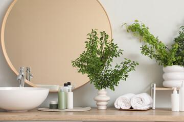 Interior of bathroom with green branches near sink