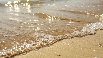 Gentle Ocean Waves Washing onto Sandy Beach. Small waves roll over golden sand as sunlight reflects off the water, capturing a peaceful seaside moment in warm tones