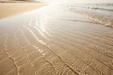 Sunlit Ocean Waves Gently Washing Sandy Beach. Soft waves ripple across a golden sandy beach under warm sunlight, creating a peaceful and serene coastal scene
