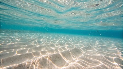 Clear Shallow Tropical Ocean Water Underwater View. Underwater view of transparent tropical sea with sunlight patterns on sandy ocean floor, capturing serenity and pristine natural beauty