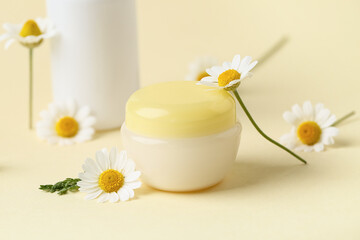 Natural cosmetic products and chamomile flowers on color background