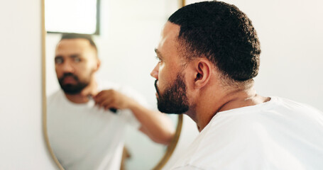 Fototapeta premium Man, razor or shaving beard at mirror in bathroom for grooming, clean face or self care routine. Hygiene, reflection or person with cosmetics tool in home for facial hair trim, skincare or depilation