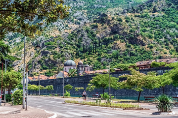 Historic city walls of Kotor with the Church of St. Nicholas and lush mountain greenery. Peaceful...
