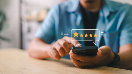 Customer using smartphone to give 5-star rating and feedback on digital interface. Concept of online review, user experience, satisfaction, mobile survey, and feedback system.