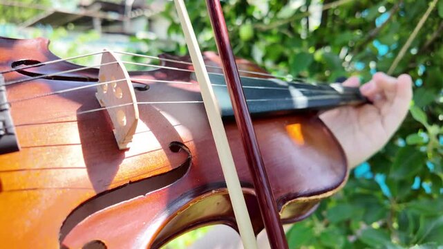 playing the violin. slow motion video violinist playing the violin. bow goes along the string. string musical instruments. learning to play a musical instrument.