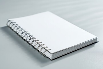 A4 format spiral binding notebook mock up on white marble background.