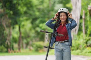 Young woman wearing helmet while riding electric scooter in park