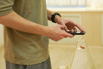  Person uses smartphone camera to capture detailed image of art piece in gallery