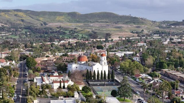 Aerial footage of San Juan Capistrano, California, showcasing the iconic Mission San Juan Capistrano with scenic rolling hills in the background.