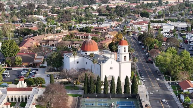 Aerial footage of San Juan Capistrano, California, with a detailed view of the Mission San Juan Capistrano, adjacent tennis courts, and the historic downtown corridor.