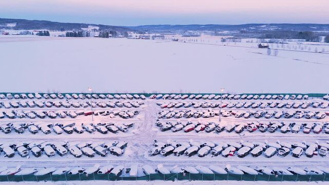 Discarded wrecked vehicles covered in snow in winter in scrapyard, aerial view
