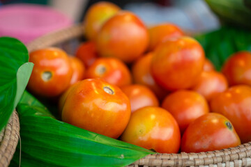 Group of fresh tomato in basket that selling at vegetable local market, object close-up with selective focus.