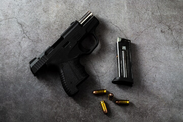 Handgun with Magazine and Bullets on Concrete Surface Background
